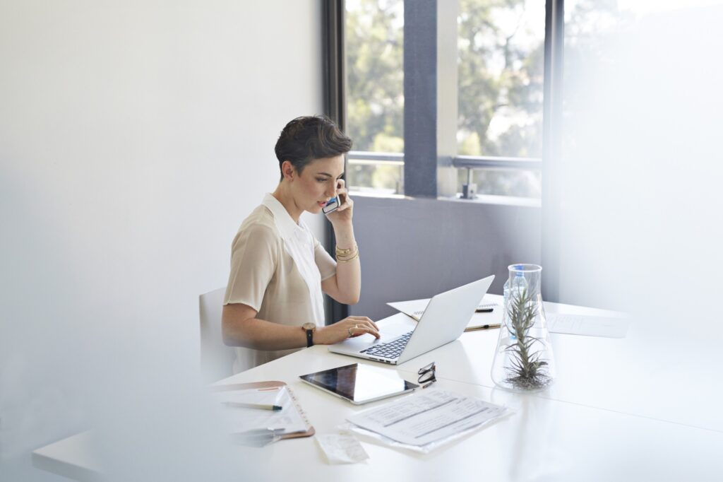 Mulher em frente ao computador buscando sobre controle de notas fiscais