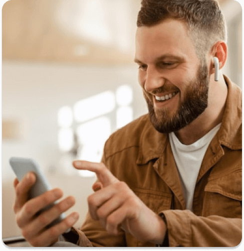 homem sorrindo segurando um smartphone